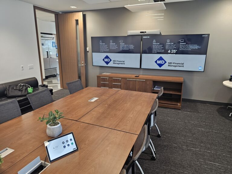 Large boardroom with dual-screen AV and conferencing system by Alanson Media